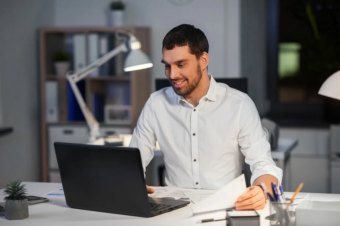 Homme assis devant son ordinateur Un homme assis à son bureau devant son ordinateur