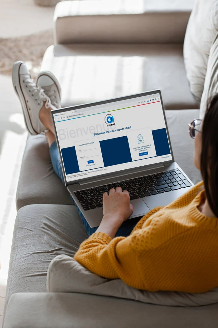 BlueTrust Certifluides Une femme sur un canapé consulte le site BlueTrust Certifluides sur son ordinateur portable